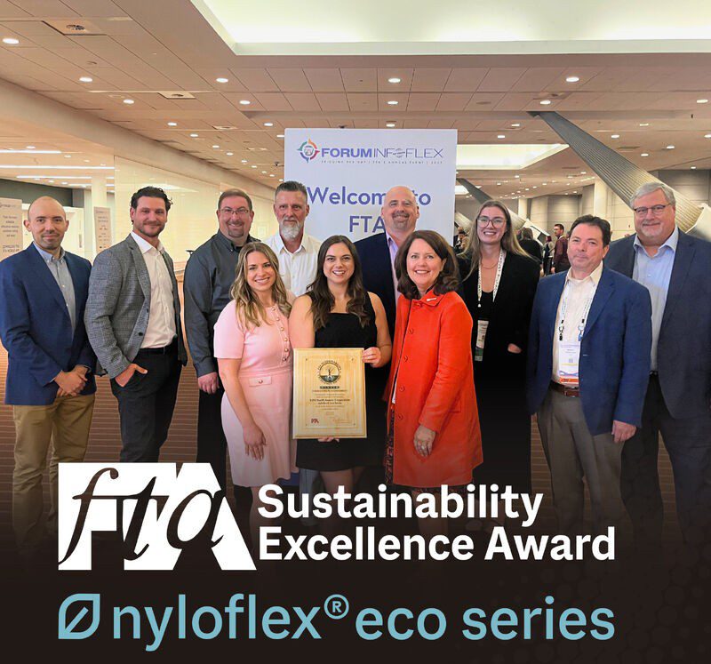 Group from XSYS standing with wooden award plate