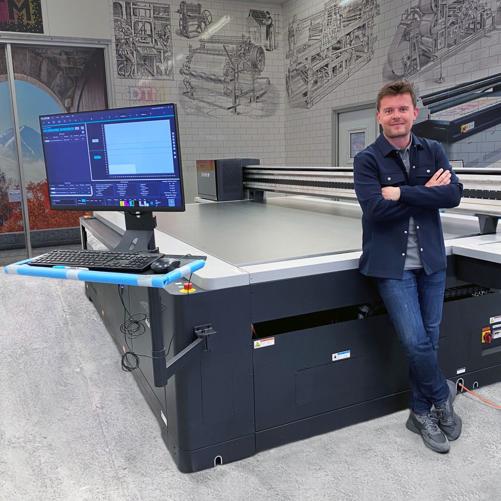 Liam Cameron, Head of Print at Peerless, stands alongside the new Fujifilm Acuity Prime L printer from Soyang Hardware