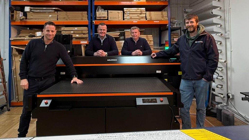 The team from Redmond Signs stand around the new Mutoh 1462UF flatbed UV printer