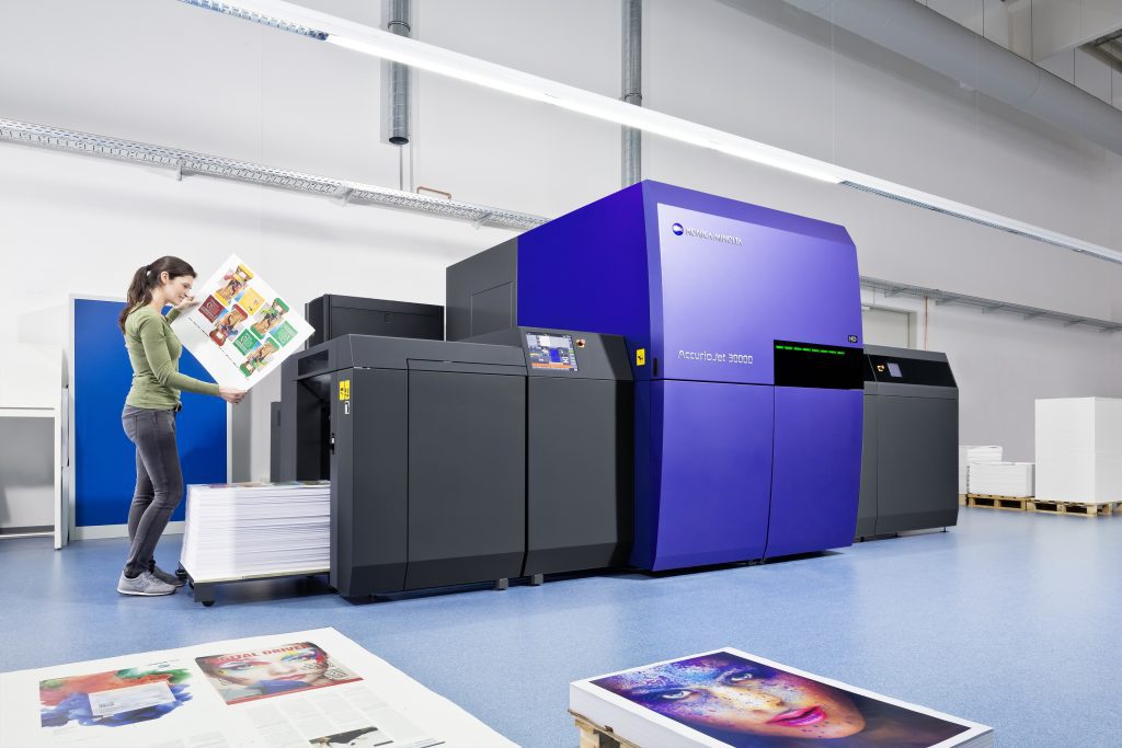 image shows woman looking at poster printed on new AccurioJet 30000 digital UV inkjet press