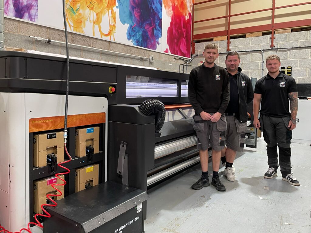 Members of the MX Display team alongside the HP Stitch S1000.