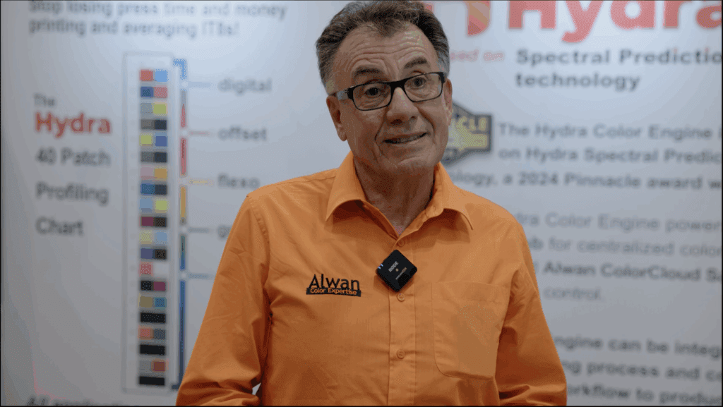 Portrait of Elie Khoury, founder of Alwan Color Expertise, standing in front of the Hydra 40 Patch Profiling Chart on the exhibit floor.