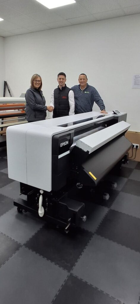 Owners of Signs and Imaging with the SEDO director next to their new Epson SureColor S9100 eco-solvent wide-format printer.