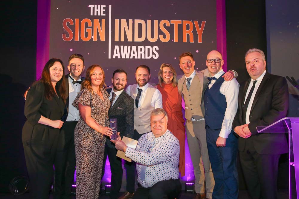 A group photograph of the William Smith team on stage receiving the Best Customer Support Award trophy.