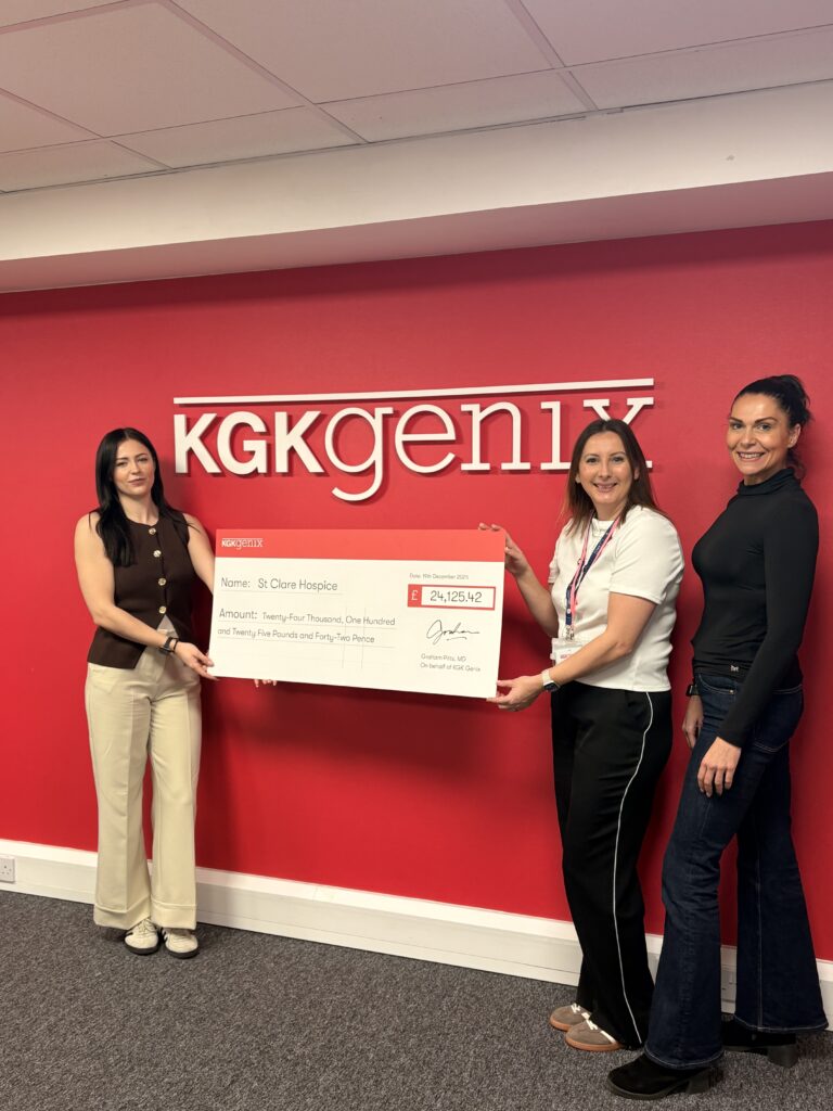 Three women holding a cheque from KGK Genix to St Clare Hospice