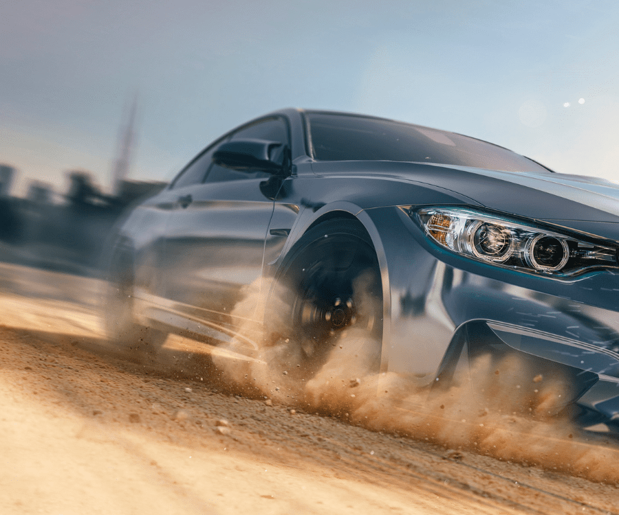 High end car wrapped in paint protection film from William Smith driving over dusty road