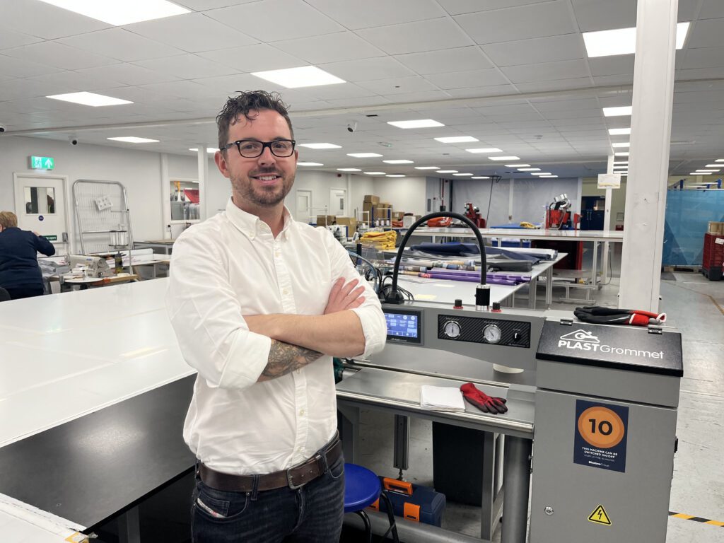 Mark Young, Managing Director of Route 1 Print's parent company Bluetree Group in front of a PLASTgrommet machine