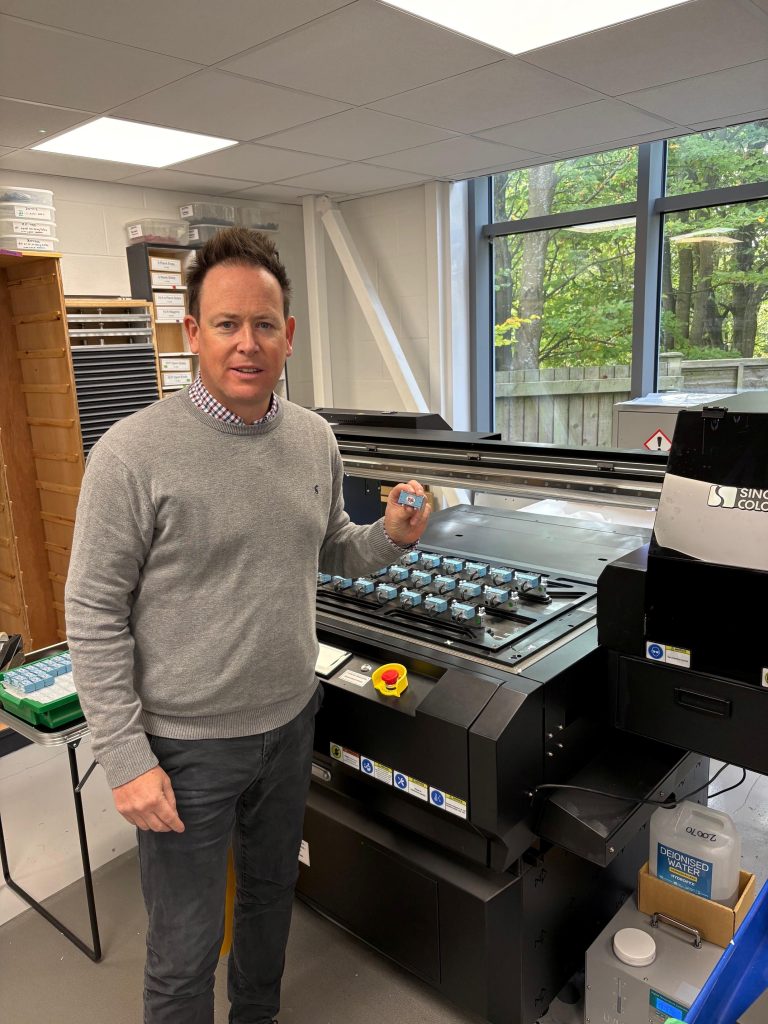 PECO’s Tim Vincent shows off the high-quality direct-to-object print capability of the SinoColor FB-0906 UV flatbed printer