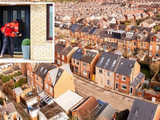 An aerial view above the rooftops of run down back to back terraced houses on a large residential estate in the North of England
