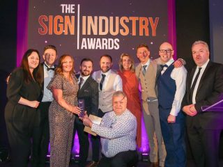 A group photograph of the William Smith team on stage receiving the Best Customer Support Award trophy.