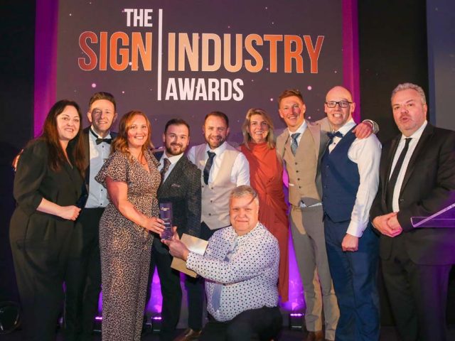 A group photograph of the William Smith team on stage receiving the Best Customer Support Award trophy.