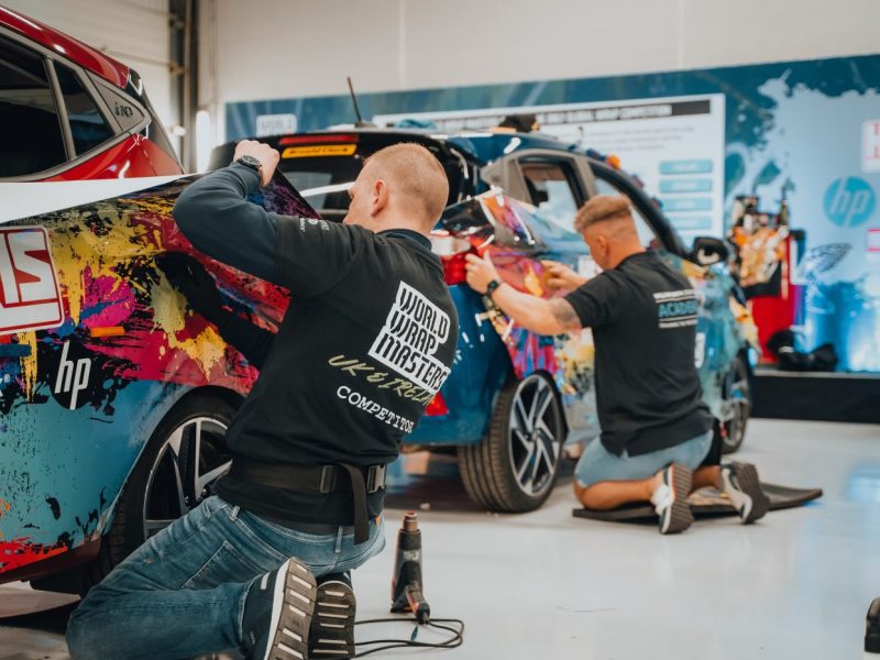 Men wrapping cars at WrapFest 2024