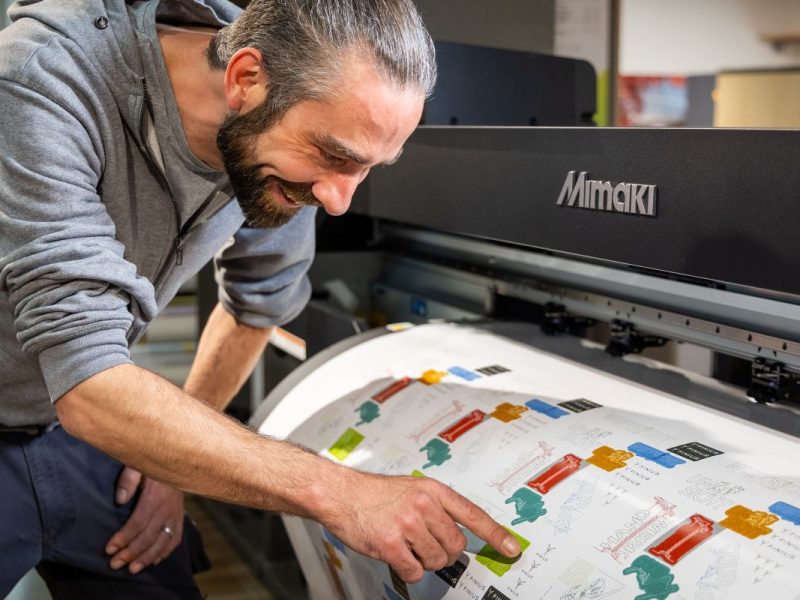 Man examining print output from a Mimaki printer