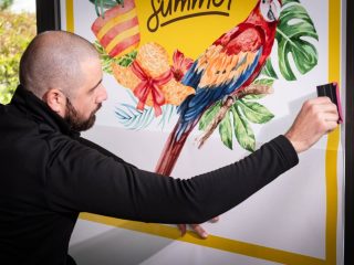 Man applying F-Print Natural Fibre 115 from Dorotape, printed with a colourful summer image