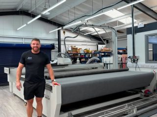 Thomas Swales, Director of Elite Sign Solutions (ESS), stands alongside the new VeloBlade Nexus 3032, purchased from Soyang.