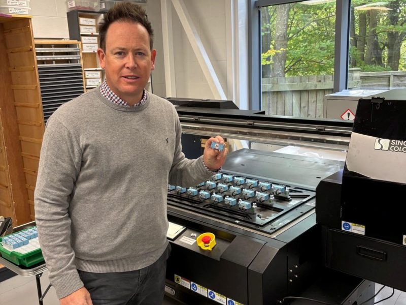 PECO’s Tim Vincent shows off the high-quality direct-to-object print capability of the SinoColor FB-0906 UV flatbed printer
